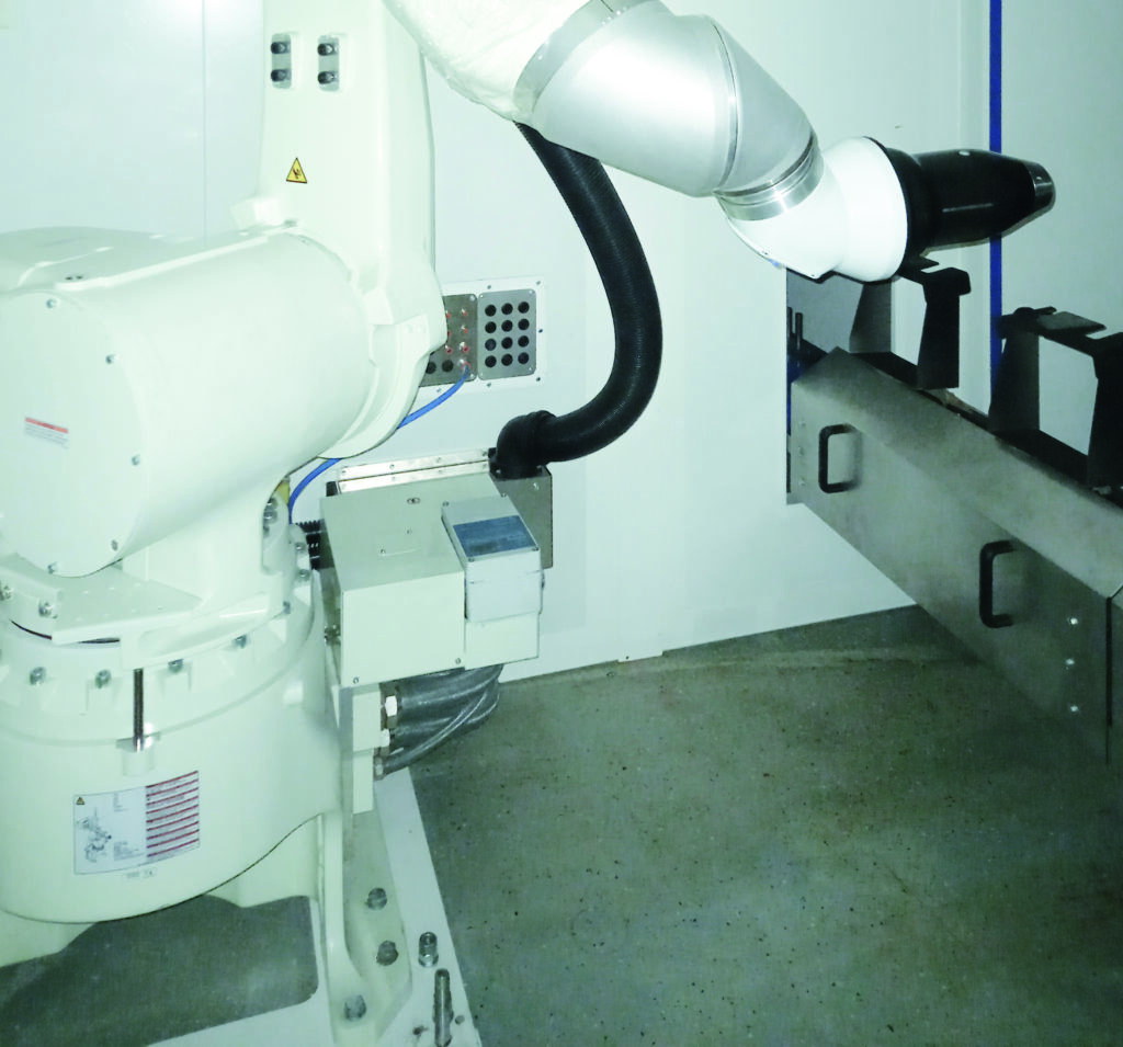 Ein Hochrotationszerstäuber auf einem Roboter lackiert Kunststoffteile.