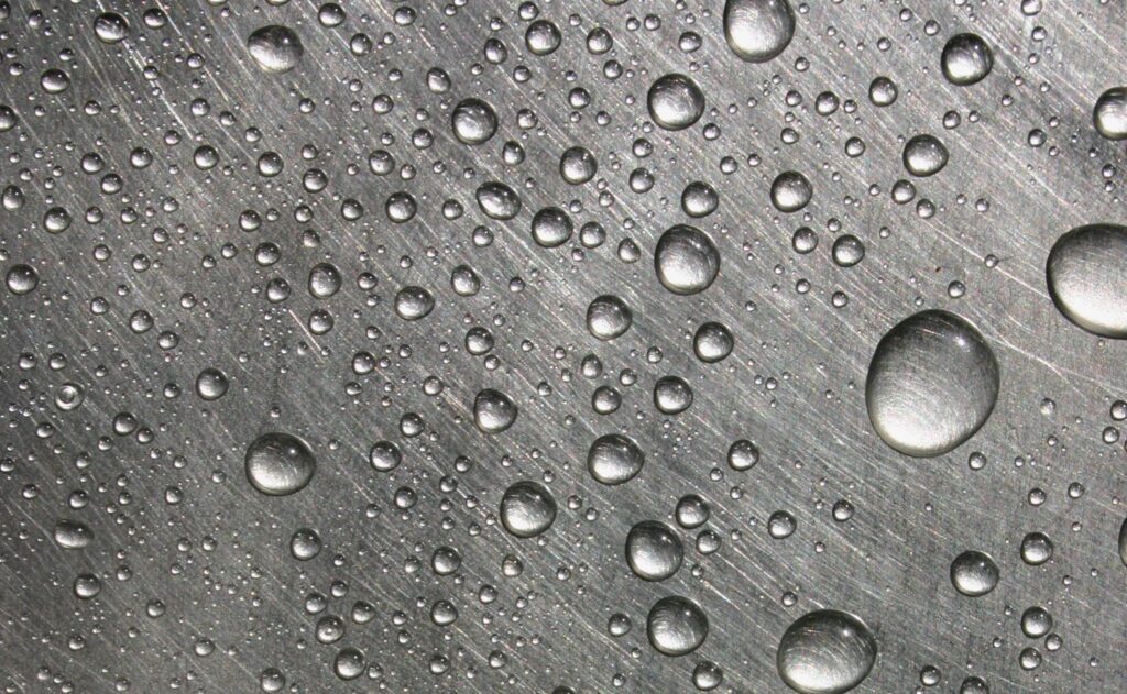 Wassertropfen auf einer Metalloberfläche vor dem Haftwassertrockner.