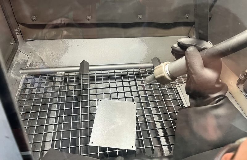Ein Werker strahlt ein Prüfblech