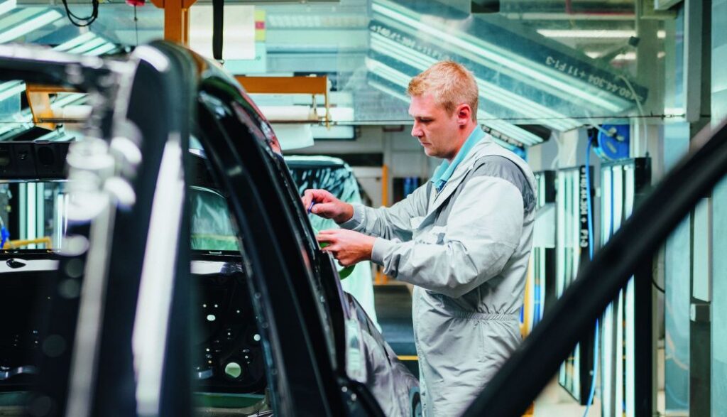 Ein Werker überprüft die Qualität der Lackierung