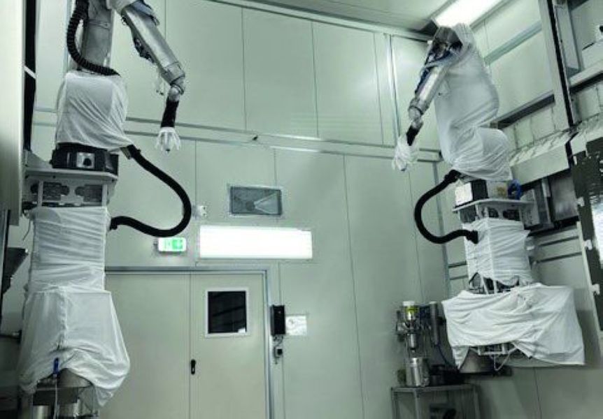 Zwei Lackierroboter in einer Kabine