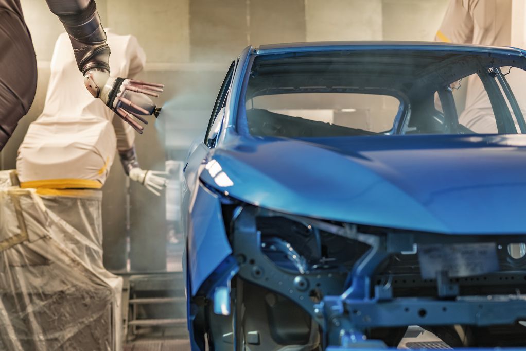 Car is getting painted by indutrial paint robots