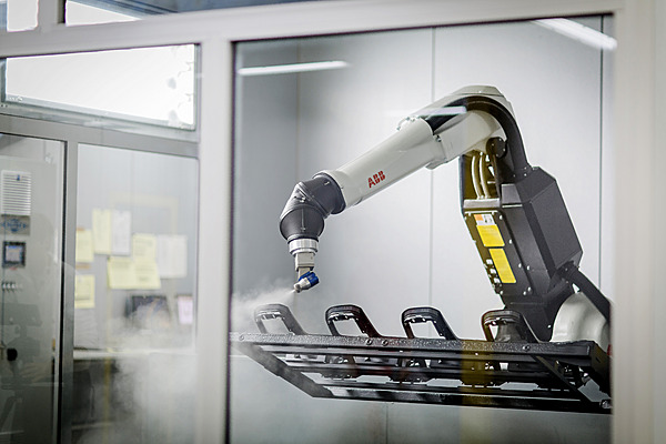 Ein Lackierroboter lackiert ein Bauteil