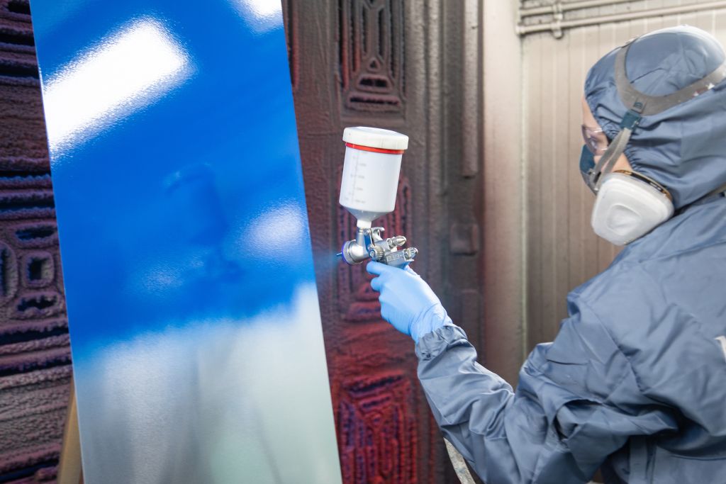 Mann lackiert ein Testblech